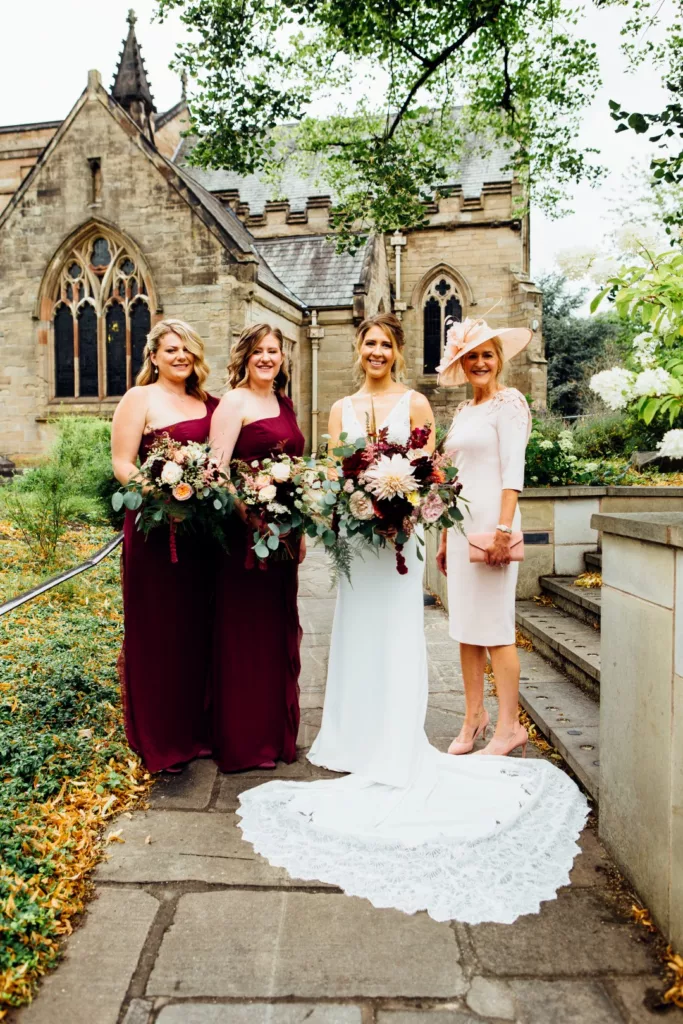 bride, bridesmaids and mother of the bride with flowers outside St. Marys, Moseley, Birmingham