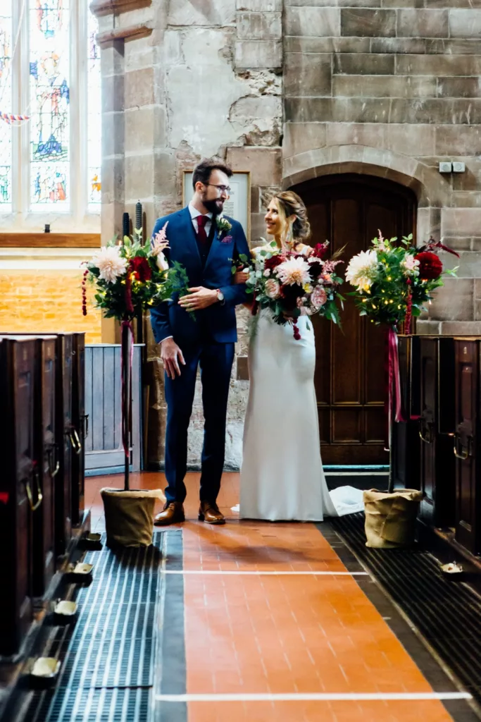 Church aisle decorated with seasonal wedding flowers at a Moseley wedding in Birmingham