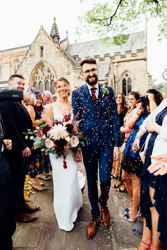Confetti moment outside St Mary’s Church Moseley with bespoke wedding flowers by Birmingham florist